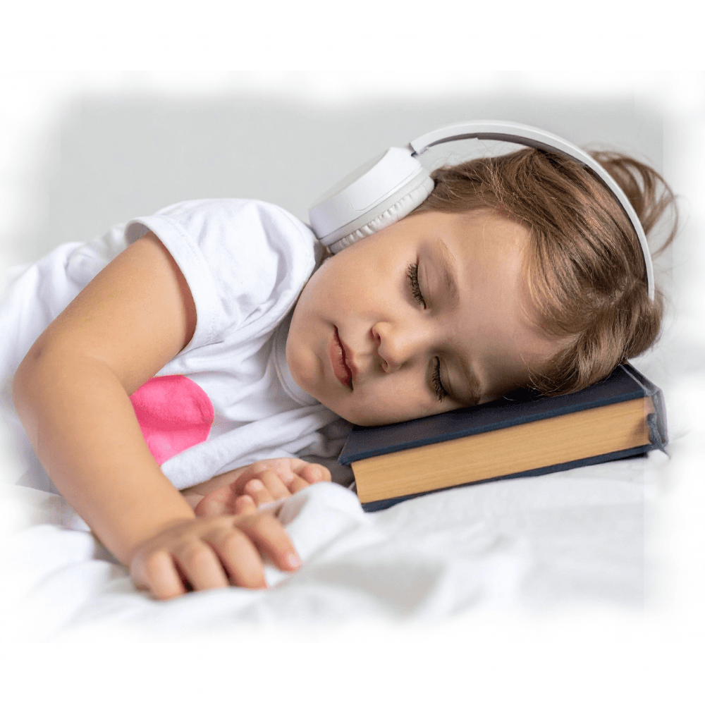 Child sleeping peacefully with headphones and book